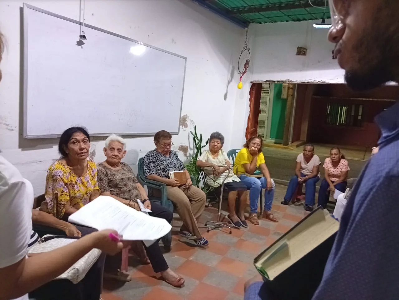 Vecinos sentados con la Biblia en las manos durante la lectura orante