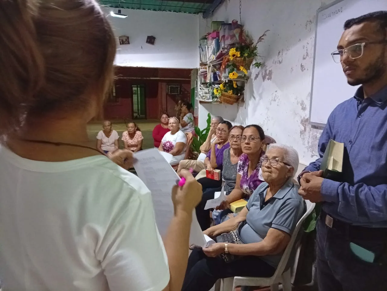 Dos animadores laicos de pie guiando el encuentro ante el grupo sentado