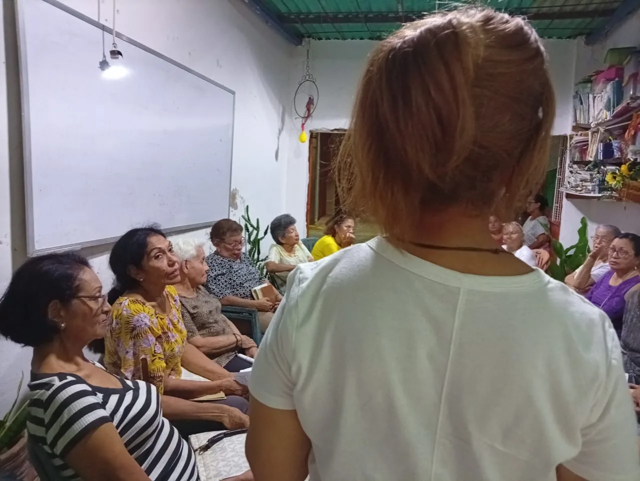 Familias, jóvenes y personas mayores del mismo sector escuchando la Palabra
