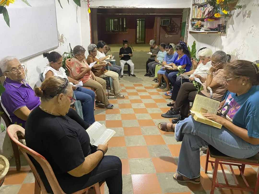 Vecinos leyendo la Biblia en círculo en un zaguán de piso de cuadros naranjas