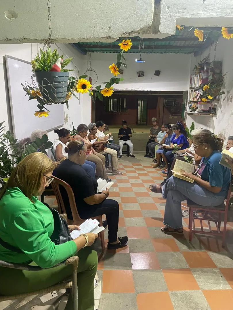 Zaguán con girasoles donde una comunidad lee la Palabra sentada en círculo