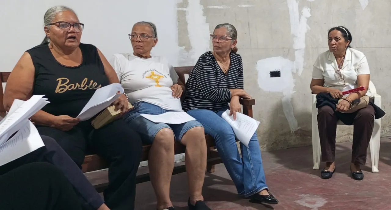 Cuatro participantes leyendo juntas el Evangelio en un patio