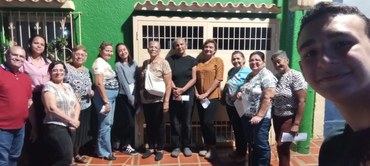 Comunidad posando frente a un portón verde tras el encuentro